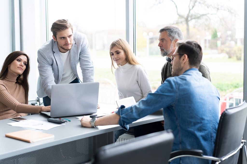 Meinungsaustausch. Eine Gruppe junger, moderner Menschen in Smart Casual Kleidung diskutiert geschäftliche Themen in einem kreativen Büro.