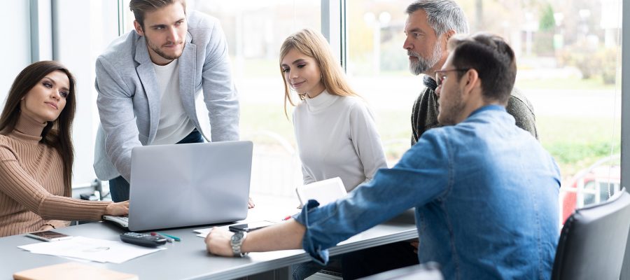 Meinungsaustausch. Eine Gruppe junger, moderner Menschen in Smart Casual Kleidung diskutiert geschäftliche Themen in einem kreativen Büro.