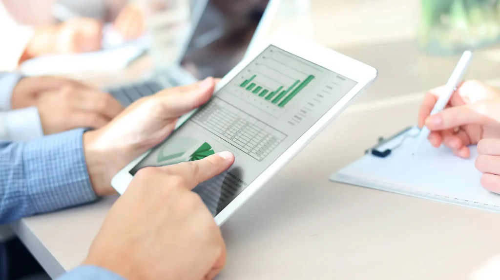 Projektmanager:in zeigt mit dem Finger auf den Nachhaltigkeitsbericht mit den ESG-Kriterien.